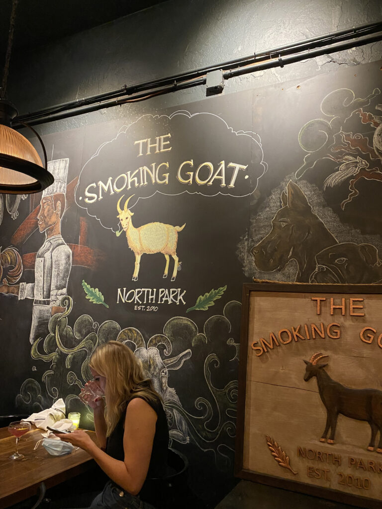 Chalkboard with pictures of goats and The Smoking Goat written on it at the entrance