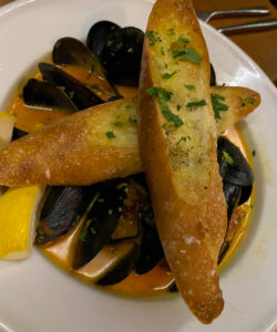 PEI (Prince Edward Island) Mussels floating in a garlic, tomato, chorizo broth