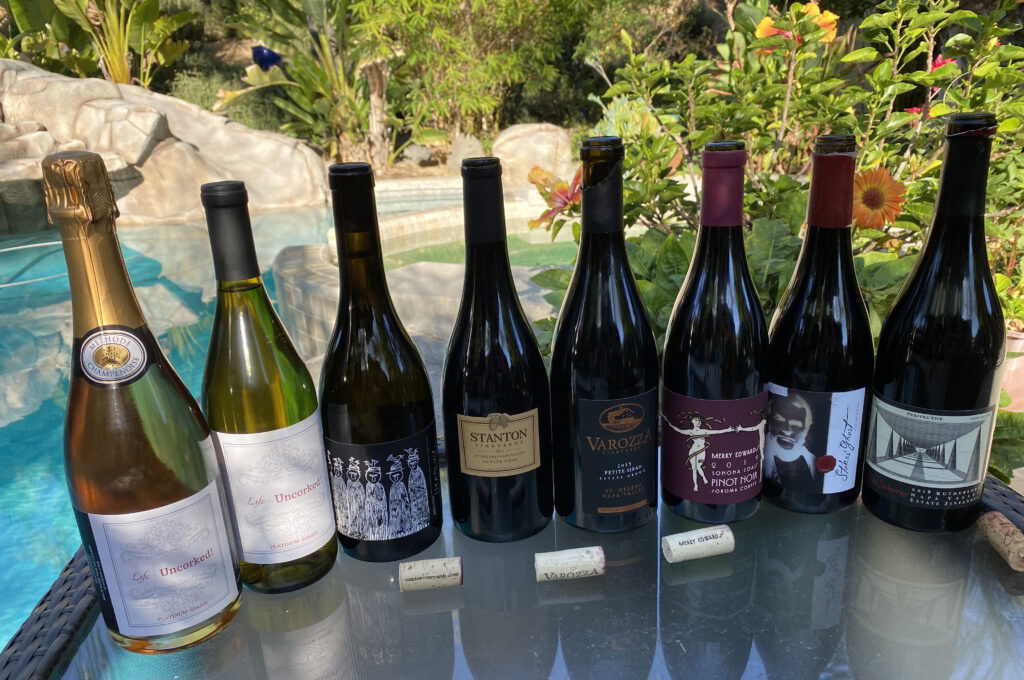 Eight Wine Bottles Lined Up Near the Pool