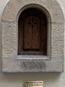 Small wine window built into castle walls for patrons to buy wine