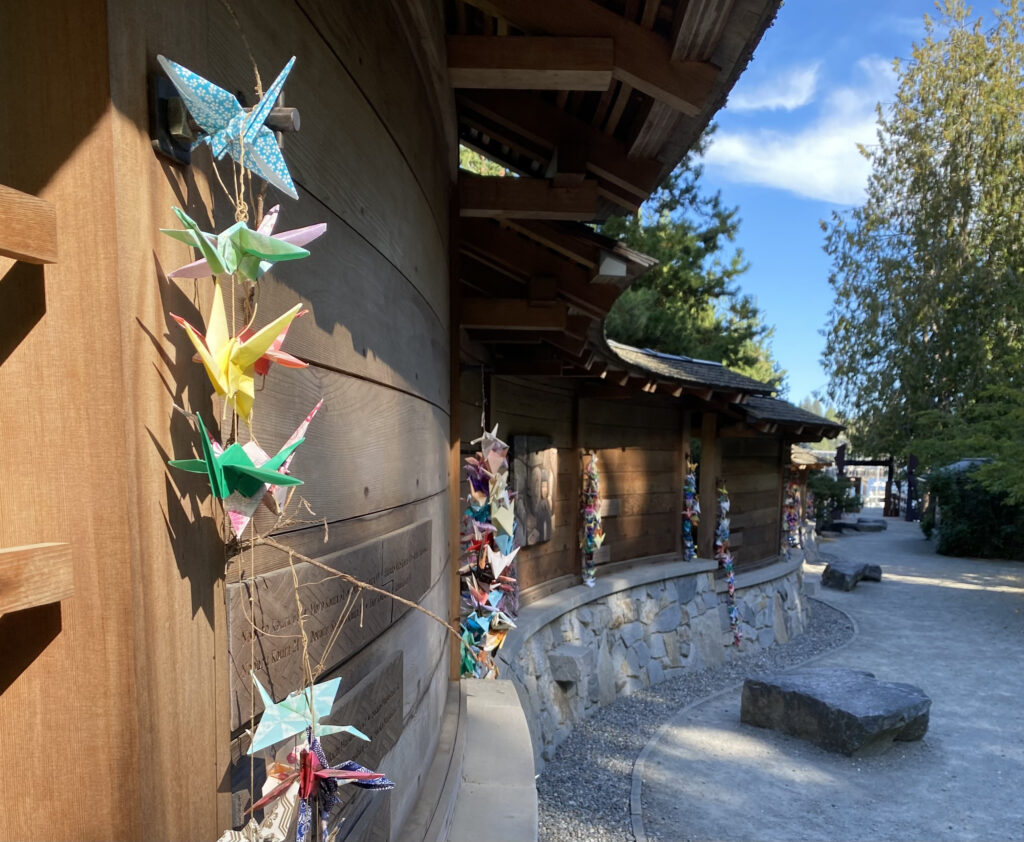 Curved Wooden Wall with Origami Birds Leading to the Boat Dock