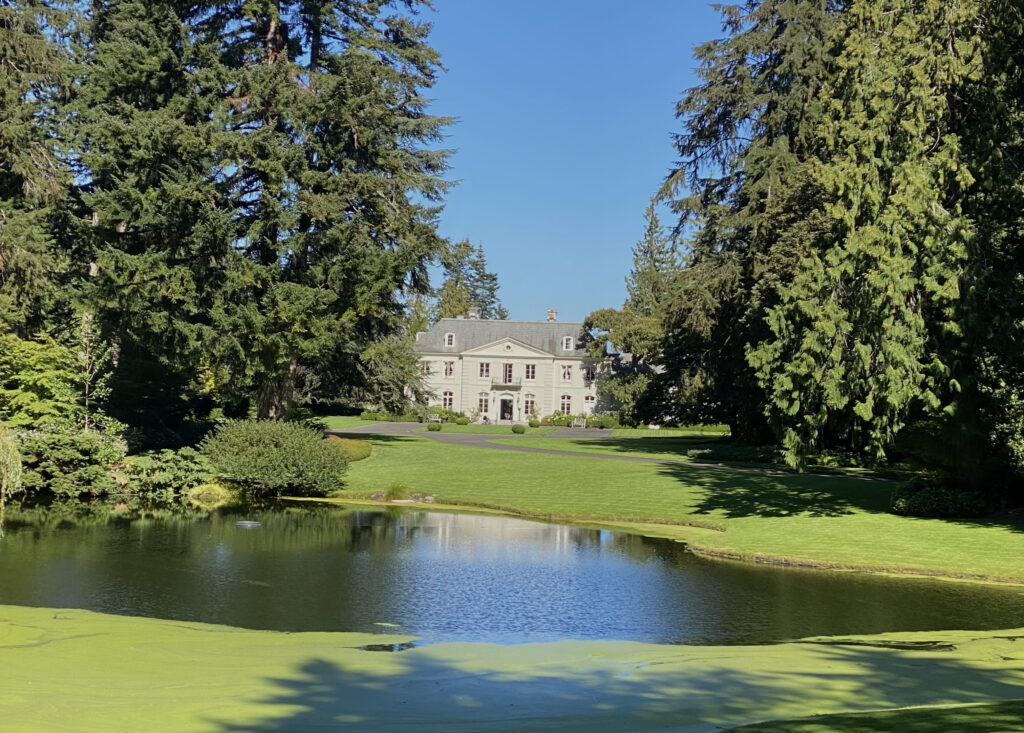 Bloedel Reserve view of the mansion surrounded by evergreens with a lake in front