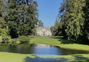 Bloedel Reserve view of the mansion surrounded by evergreens with a lake in front