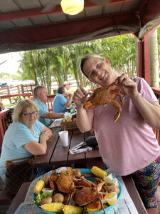 owner Kelly Beall holding up a blue crab