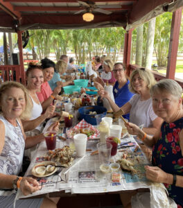 IFWTWA Media Group at the table spread with newspaper and a feast of seafood