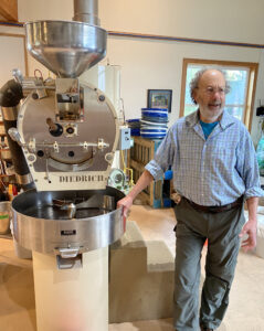 Part Owner David Adler standing next to the coffee roaster at Pegasus Coffee