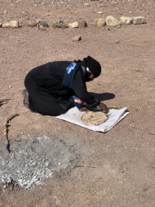 Raifa, Hussein's mother cleaning off ashes from baked bread