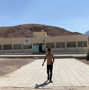 Wadi Feynan school with young school child waving to us on our walk