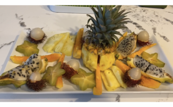 Exotic fruit tray of dragon fruit, star fruit, papaya, baby pineapple, and rambutan
