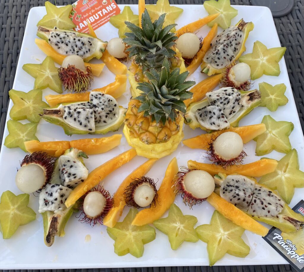 Fruit tray with exotic fruits of papaya, star fruit, dragon fruit, and baby pineapple