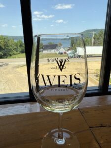 Weis Vineyards Wine Glass with Zum Wohl Printed on Back and View of the Lake in the Background